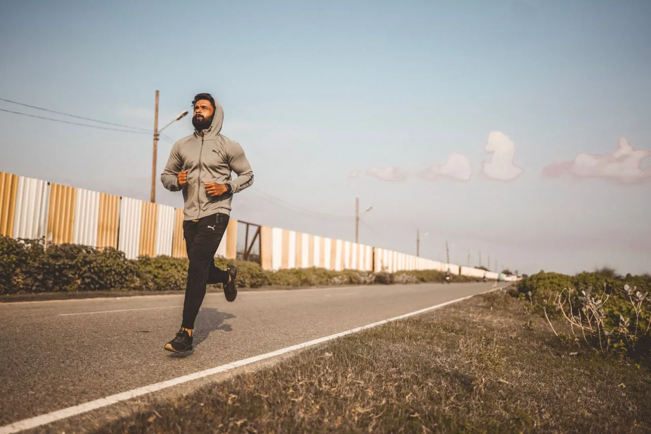 Corredor con sudadera entrenando en carretera