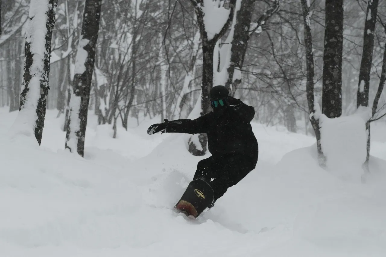 Snowboarder girando en nieve polvo en Japón